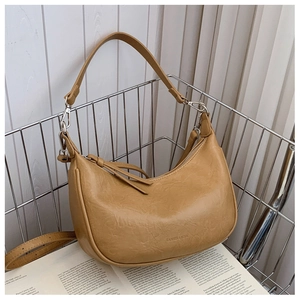 Detailed close-up of khaki faux leather texture with brand embossing on minimalist handbag
