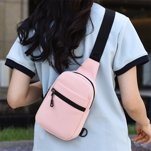 Détail d'un sac de poitrine en nylon rose avec poche zippée et bandoulière réglable