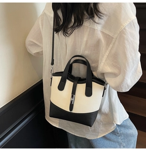 Dettaglio della borsa tote bicolore in pelle martellata con fibbia argentata e tracolla