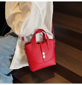 Close-up of red leather tote bag with silver twist lock and textured litchi pattern