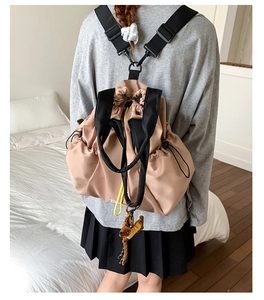 Close-up of the adjustable drawstring side and high-density nylon texture of the beige backpack