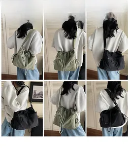 Detail of dark green and black drawstring crossbody bags with double front zipper pockets