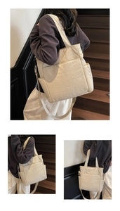 Dettaglio della borsa tote beige in tessuto testurizzato con tasche laterali su scale