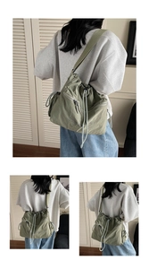 Detail view of military green nylon drawstring tote bag with YOU BEAR print and side pockets