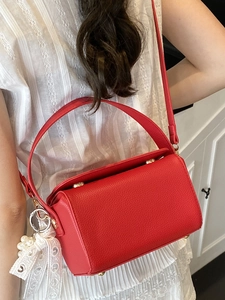 Sac à main boîte rouge en cuir grainé avec breloque perle et dentelle sur modèle