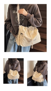Detail of beige drawstring crossbody bag with YOU DEAR text and adjustable strap