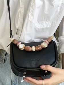 Minimalist black lychee leather saddle bag with marble beaded handle for 2025 summer