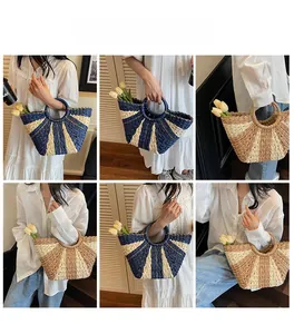 Detail of handmade woven straw handbags in navy and brown with round handles