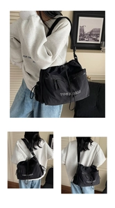Detail view of black drawstring crossbody bag with multiple zipper pockets and wide strap