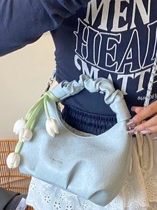 Sac à main bleu clair en forme de demi-lune avec chaîne et breloque fleurie