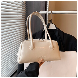 Detail of off-white leather Boston bag with embossed brand logo and dual handles