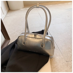Detailed view of silver metallic Boston bag with crinkled texture and long handles