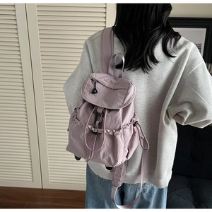 Rear view of a light purple lavender nylon backpack with flap and drawstring closure details
