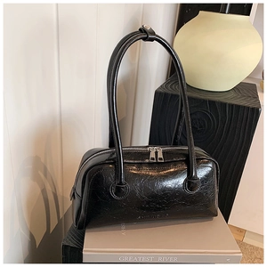 Detail of black glossy oiled leather bag showing silver double zippers and brand logo