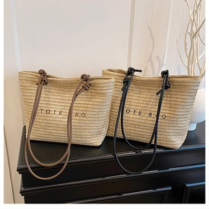 Detail of straw tote bags with beige woven texture and contrasting leather shoulder straps