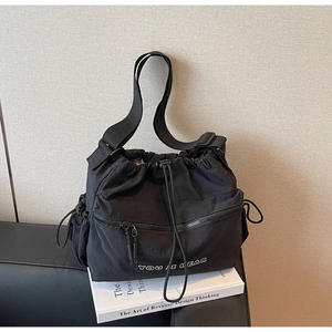 Detail of black drawstring crossbody bag with YOU JI BEAR logo and side pockets