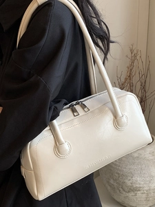 Minimalist creamy white Boston shoulder bag in matte leather featuring embossed logo detail