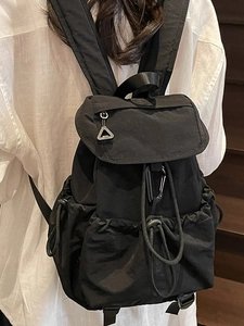 Minimalist black nylon backpack for women featuring drawstring closure and outdoor style