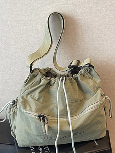 Minimalist olive green nylon drawstring crossbody bag with a large capacity and wide strap