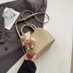 Détail du sac seau abricot avec texture litchi et pendentif ourson mignon