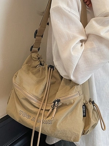 Khaki nylon crossbody bag with drawstring pleated design and adjustable shoulder strap