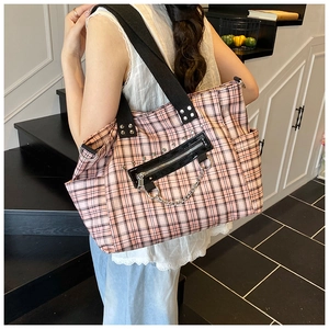 Detail of pink plaid canvas tote bag featuring silver metal chain and black zipper patch