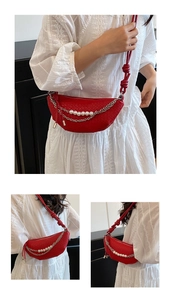 Close-up detail of red woven dumpling bag featuring elegant pearl and metal chain accents