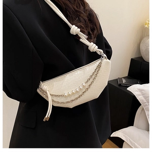 Detail of white woven crescent bag with pearl chain and knotted rope strap