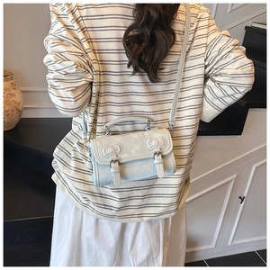 Vue détaillée du sac vert menthe avec nœuds décoratifs et boucles métalliques élégantes
