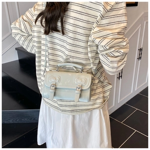 Détail du sac à bandoulière bleu clair avec nœuds gaufrés et brides à boucle style d'été