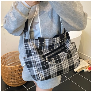 Detail of checkered gothic punk tote bag with metal chains and side pocket detail