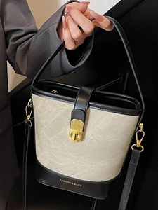 Minimalist beige and black bucket bag with gold hardware and logo for daily commute
