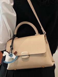 Chic beige square handbag with round handle, metal buckle, and Trojan horse pendant