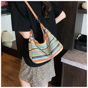Detail showing the colorful woven texture and brown leather strap of the summer beach bag