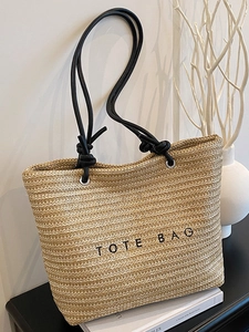 Summer woven straw tote bag with black embroidery and leather handles for beach vacation