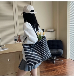 Close-up of black and white striped woven tote bag with premium leather handles