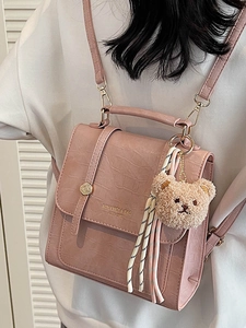 Pink faux leather crossbody bag with crocodile texture and cute bear charm decor