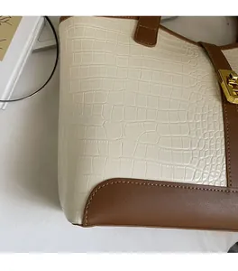 Detailed close-up of crocodile embossed leather tote bag with elegant gold twist lock