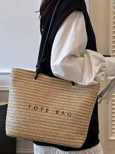 Straw tote bag with black TOTE BAG embroidery and shoulder straps for summer beach travel