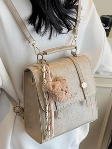 Retro beige crocodile pattern backpack with plush bear and striped scarf detail