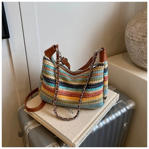 Detail of colorful woven straw bag with leather strap and silver chain handle texture