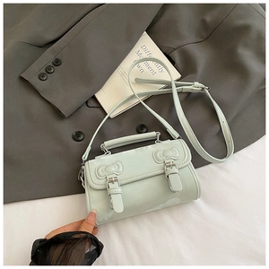 Détail du sac à main vert menthe avec nœuds décoratifs et boucles en métal rétro