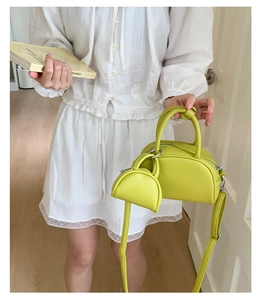 Détail du sac à main demi-lune vert citron avec texture litchi et mini porte-monnaie