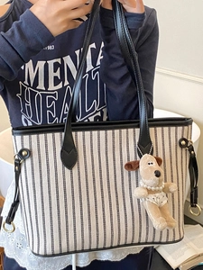 Vertical striped canvas tote bag with black leather straps and dog plush charm for women