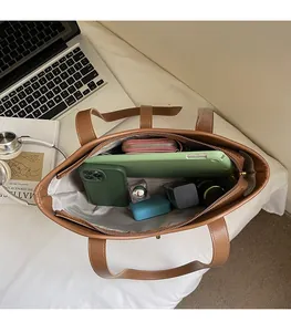 Top view of brown leather tote bag showing large interior capacity with gadgets