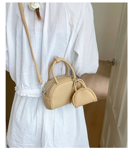 Sac bandoulière beige chic avec petit porte-monnaie assorti porté par un mannequin