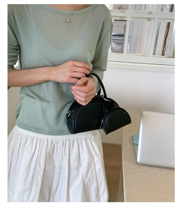 Détail d'un ensemble sac à main en cuir noir avec mini porte-monnaie et zip argenté