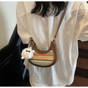 Detail of colorful rainbow woven crossbody bag with brown leather and plush charm