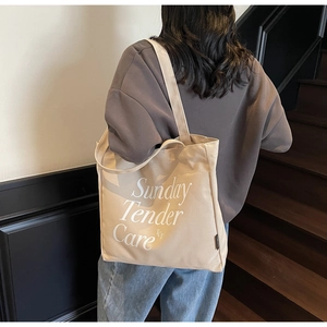 Vista dettagliata della borsa tote in tela beige con stampa Sunday Tender Care