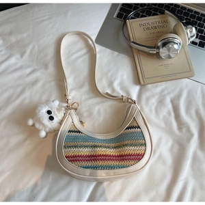 Detail of bohemian rainbow woven crescent bag with leather strap and plush charm